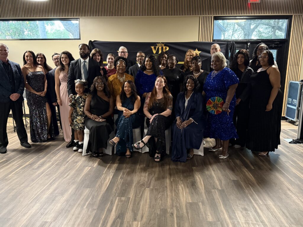 Group photo of people dressed formally at an indoor event.