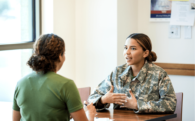 Military personnel talking at a table