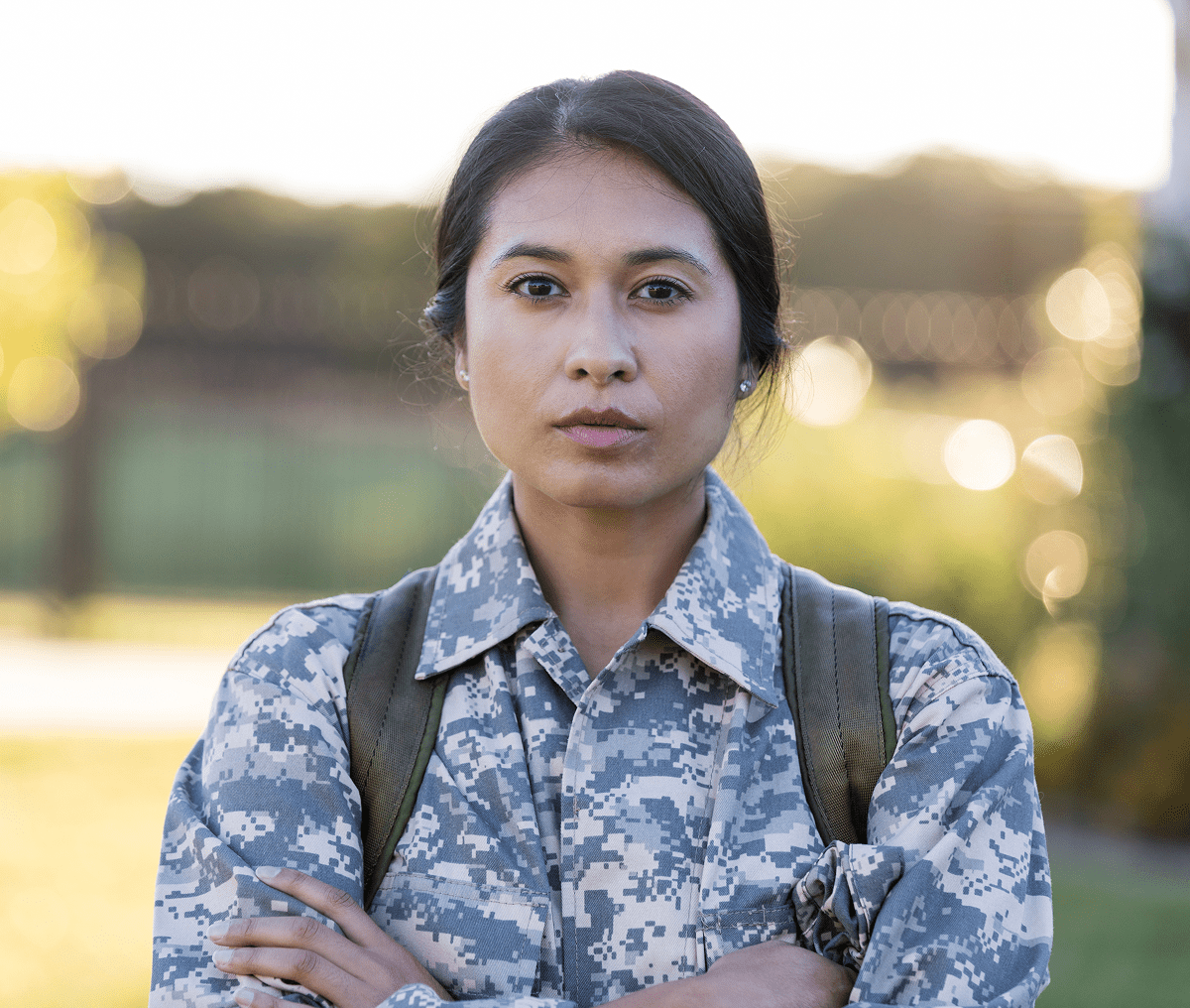 Military person with crossed arms outside